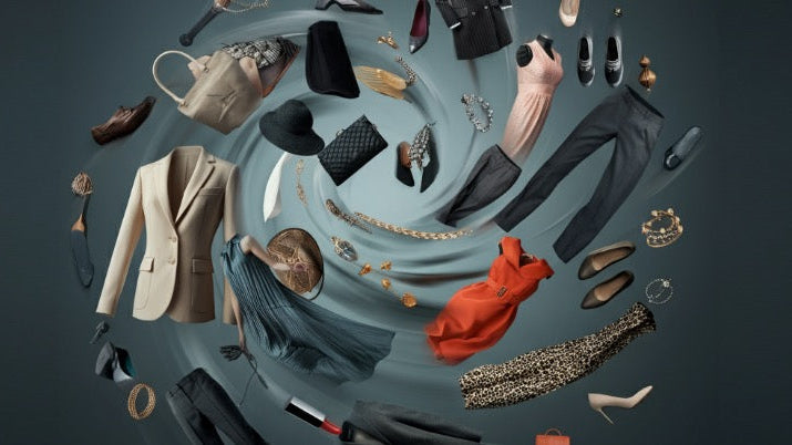 Dynamic photograph of high-end fashion items, including clothing, shoes, and accessories, swirling against a dark background, symbolizing movement, abundance, and luxury.