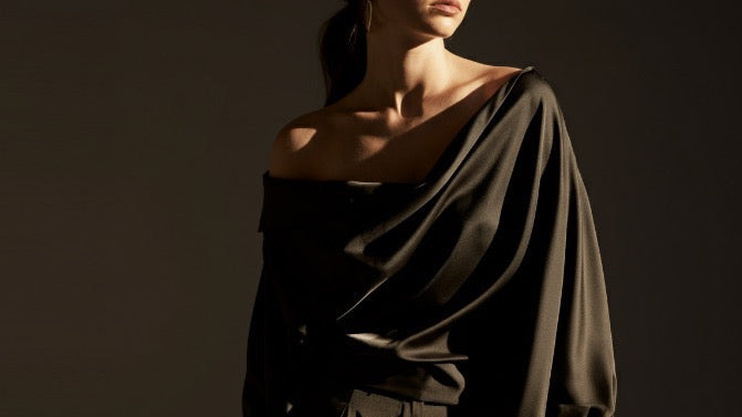 Elegant woman in a minimalist silk shirt and pants, showcasing timeless, understated luxury.